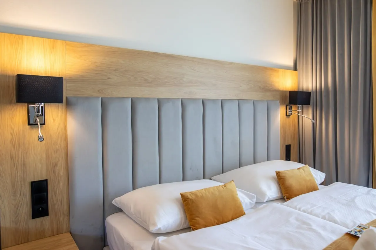 Narzuta i poduszki dekoracyjne w pokoju hotelowym